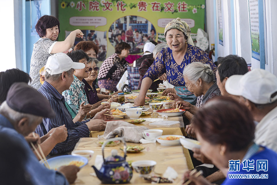 新华社照片，乌鲁木齐，2016年6月15日 新疆：沙尼汗大妈的“老人俱乐部” 在沙尼汗居家养老点，沙尼汗照顾老人们吃午饭（6月3日摄）。 包粽子、蒸抓饭、洗水果、打牌下棋……位于新疆阜康市阜新街道文化路社区的“老人俱乐部”里充满欢声笑语，宛如一个大家庭。今年54岁的沙尼汗·艾塔木经营着“老人俱乐部”，吸引了周围的老人前来作客，也让30多位各民族老人在这里安度晚年。 善良热心的沙尼汗大妈一直以来不仅孝敬公婆，还帮助周围的独居老人做饭、洗衣，陪他们聊天，她家冬暖夏凉的小院也成了老人们最爱去的地方。2010年的一天，社区书记找到沙尼汗，希望她能将社区里因子女不在身边、生活需要照顾的老年人集中到她家，成立家庭式居家养老服务点。当年末，新疆首个家庭式居家养老服务点在沙尼汗家挂牌。5年多来，沙尼汗先后照顾36位汉、回、哈萨克、维吾尔族老人，他们中年龄最大的90多岁，最小的也快60岁。“我喜欢跟老人们在一起，觉得他们就像我自己的父母亲和兄弟姐妹一样，感情太深了！”脸上始终挂着微笑的沙尼汗动情地说。 沙尼汗的善行得到了社会各界的关注，她先后荣获“全国孝亲敬老之星”“民族团结模范”等称号。在她的影响和带动下，越来越多的志愿者自发来到她家小院为老人们服务。今年3月，阜康市“情暖空巢”沙尼汗居家养老点还成为“全国百佳志愿服务项目”。 新华社记者王菲摄